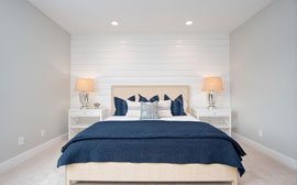 Massive king sized bed in the master suite with an elegant contemporary shiplap wall