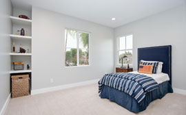 Bedroom 2 with custom built shelving and large windows allowing in plenty of natural light