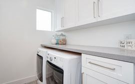 Oversized upstairs laundry room with plenty of cabinet space and room for a modern high-efficiency washer and dryer
